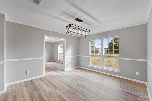 unfurnished dining area with ornamental molding, a chandelier, and light wood-type flooring