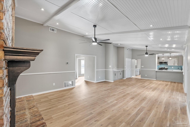 unfurnished living room featuring light wood-type flooring, ceiling fan, and beam ceiling