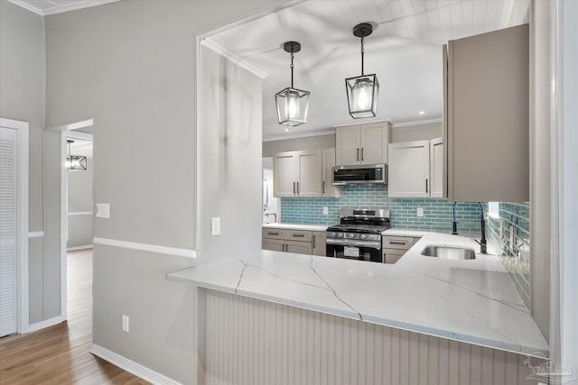 kitchen featuring sink, crown molding, hanging light fixtures, appliances with stainless steel finishes, and light stone counters