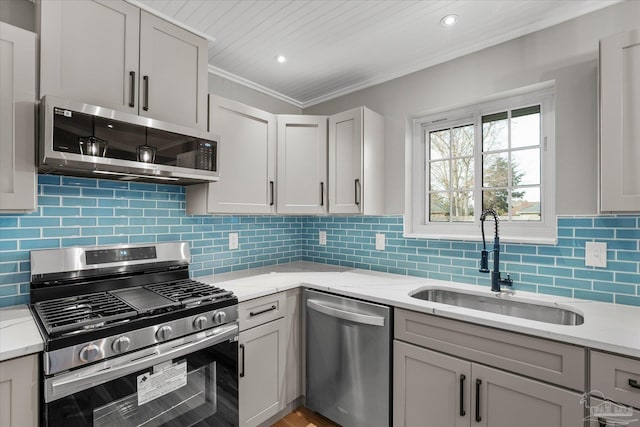 kitchen featuring stainless steel appliances, decorative backsplash, sink, ornamental molding, and light stone counters