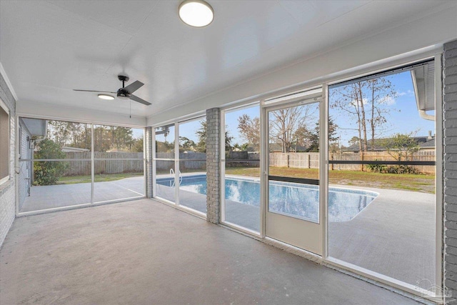 unfurnished sunroom with ceiling fan