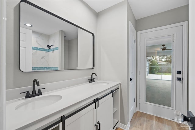 bathroom with ceiling fan, vanity, wood-type flooring, and a shower