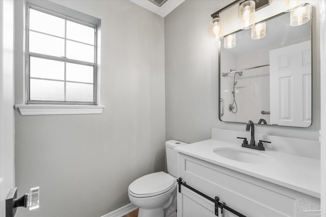 bathroom with toilet, vanity, and a wealth of natural light