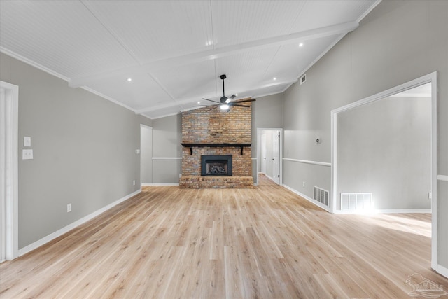 unfurnished living room featuring a brick fireplace, light hardwood / wood-style flooring, vaulted ceiling with beams, and ceiling fan