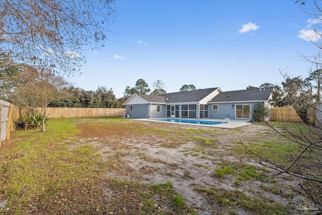 back of house featuring a fenced in pool, a patio area, and a lawn