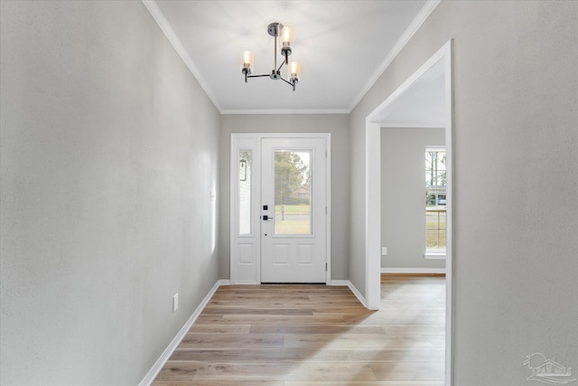 foyer with a chandelier, crown molding, and light hardwood / wood-style flooring