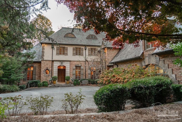 french provincial home featuring stucco siding