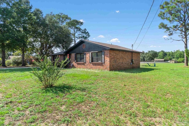 view of side of property featuring brick siding and a lawn