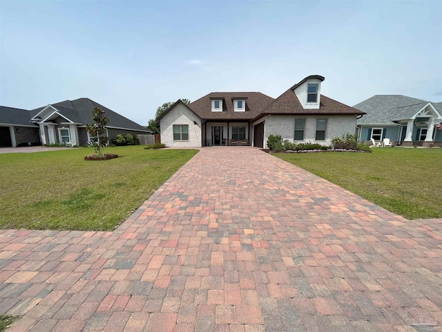 craftsman house featuring brick siding, a garage, a front lawn, decorative driveway, and a shingled roof