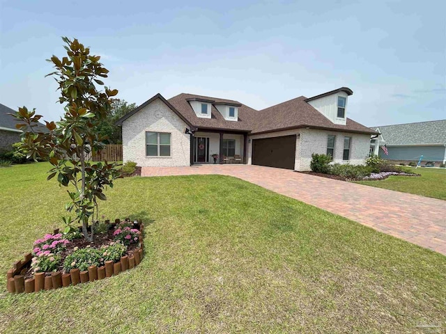 traditional home with driveway, a garage, brick siding, and a front yard