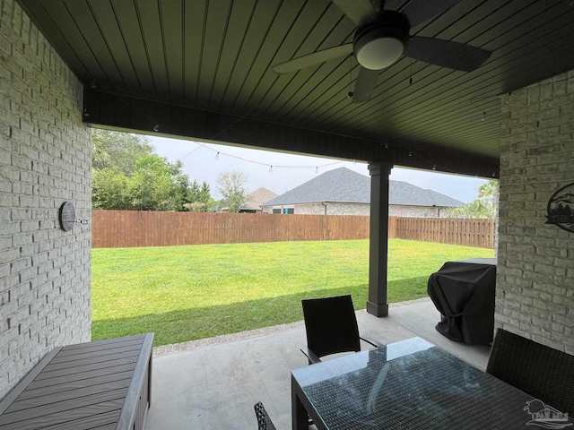 view of patio with ceiling fan, area for grilling, and a fenced backyard