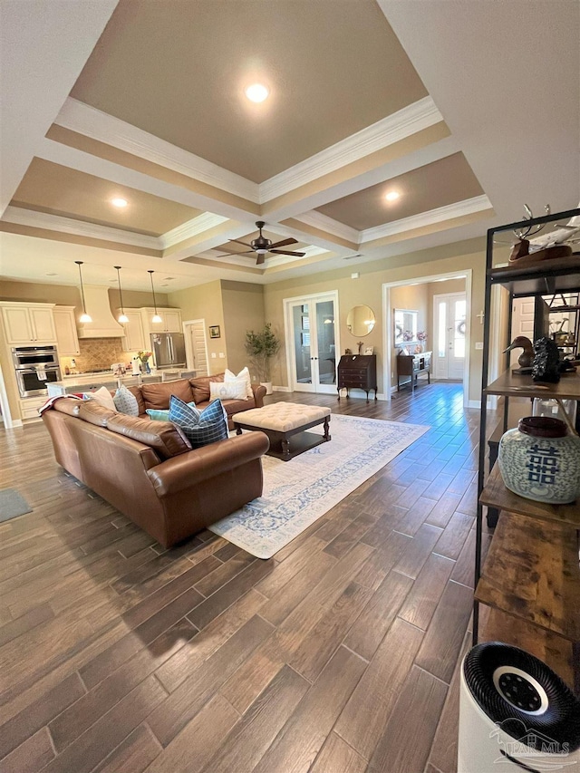 living room with a ceiling fan, coffered ceiling, baseboards, ornamental molding, and dark wood-style floors