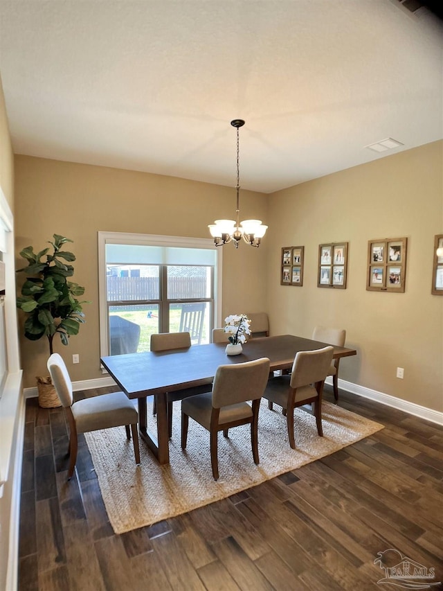 dining space featuring a chandelier, baseboards, and dark wood-type flooring