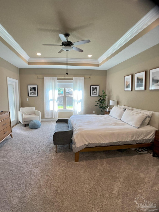 bedroom featuring a tray ceiling, carpet, and ornamental molding