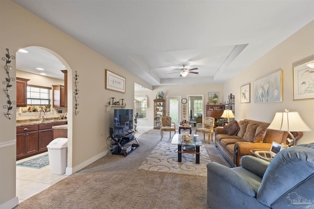 3288 Wasatch Range Loop, Pensacola, FL 32526 - living area with arched walkways, ceiling fan, a raised ceiling, baseboards, and light colored carpet