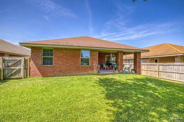 3288 Wasatch Range Loop, Pensacola, FL 32526 - back of property with a patio, a gate, brick siding, and roof with shingles