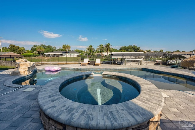 view of pool with a patio and an in ground hot tub