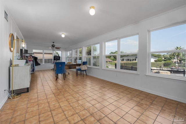 unfurnished sunroom featuring ceiling fan