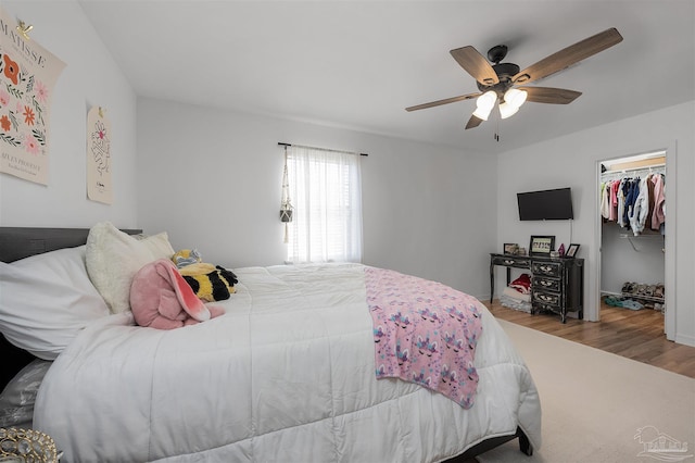 bedroom with ceiling fan, light hardwood / wood-style flooring, and a closet