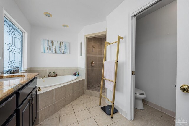 full bathroom featuring vanity, independent shower and bath, toilet, and tile patterned floors