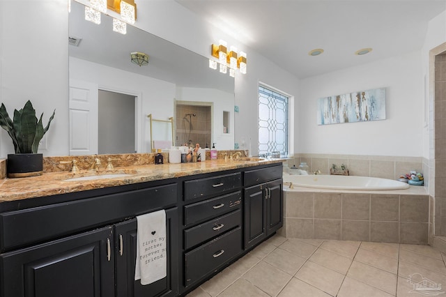 bathroom with a relaxing tiled tub, tile patterned flooring, and double vanity