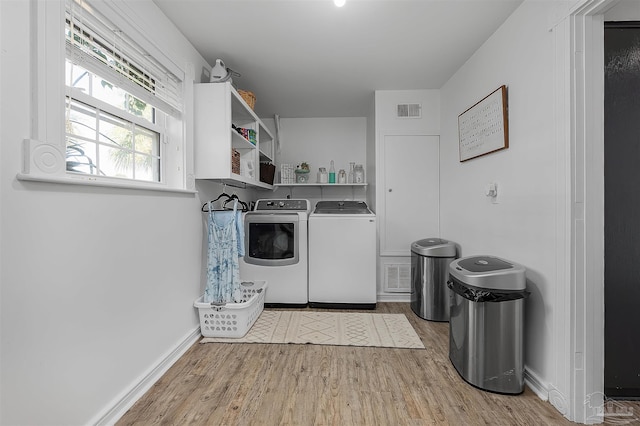 washroom featuring washer and clothes dryer and light hardwood / wood-style floors