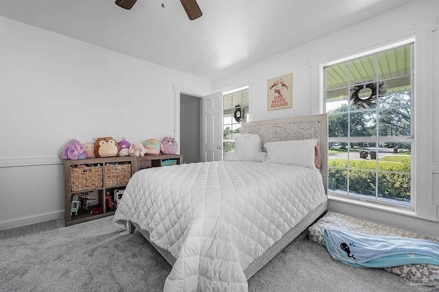 carpeted bedroom with multiple windows and ceiling fan