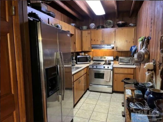 5301 Gentle Breeze Dr, Tallahassee, FL 32317 - kitchen with stainless steel appliances, under cabinet range hood, light countertops, brown cabinetry, and light tile patterned floors