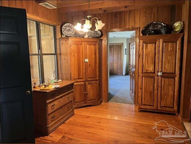 5301 Gentle Breeze Dr, Tallahassee, FL 32317 - hall with light wood-style flooring, wooden walls, a chandelier, and beam ceiling