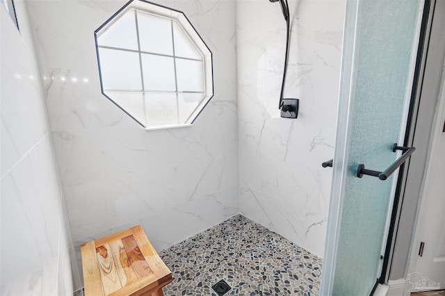 bathroom featuring a marble finish shower