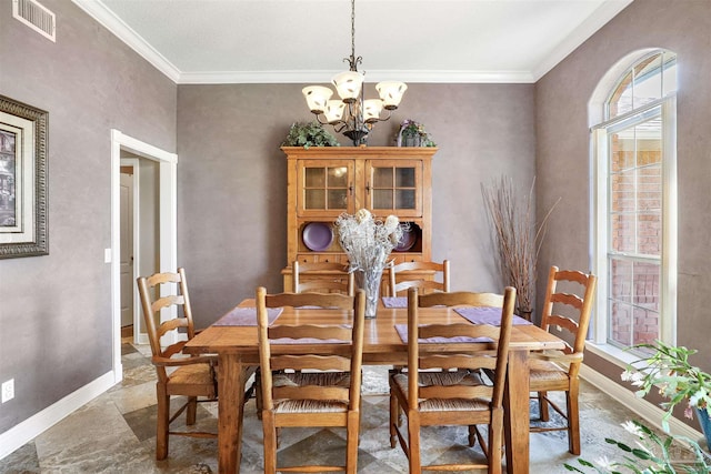 dining area with a notable chandelier, visible vents, baseboards, and ornamental molding