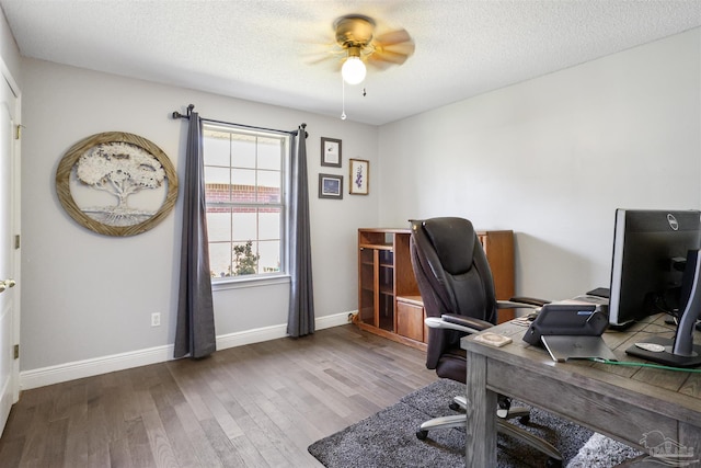 office featuring ceiling fan, wood finished floors, baseboards, and a textured ceiling