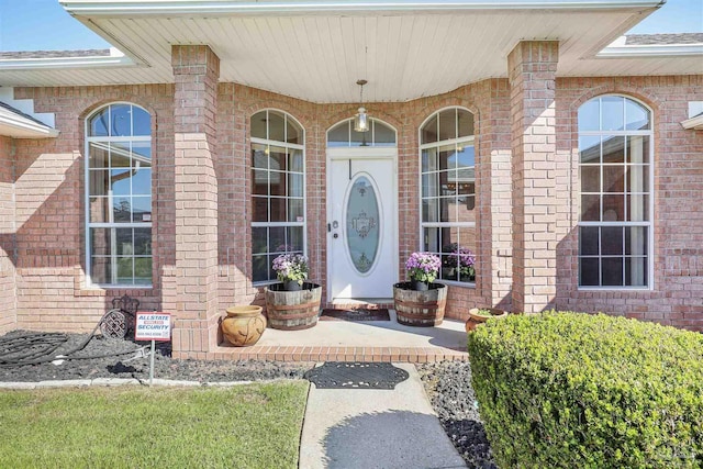 view of exterior entry featuring brick siding