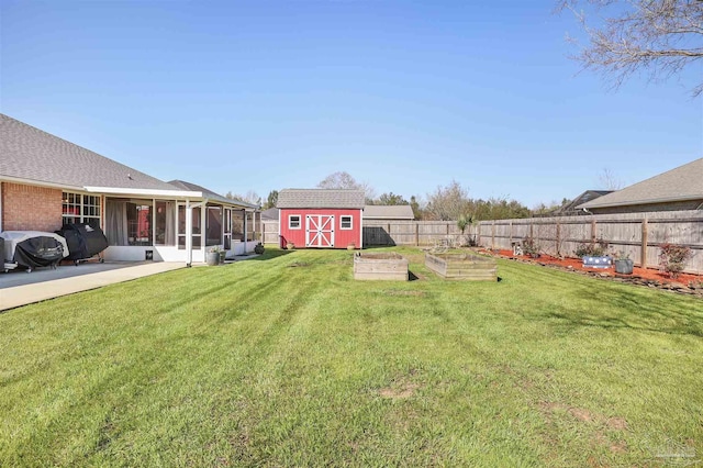 view of yard with fence, a storage shed, an outdoor structure, a sunroom, and a vegetable garden