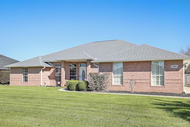 ranch-style house with brick siding, a shingled roof, and a front yard