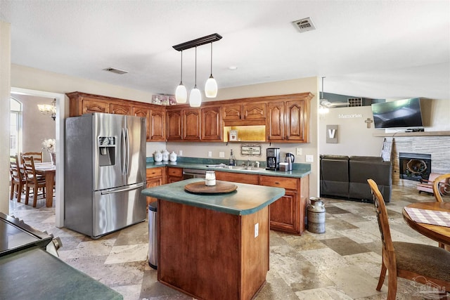 kitchen featuring visible vents, dark countertops, stainless steel fridge with ice dispenser, and stone finish floor