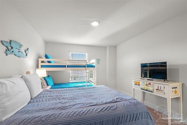 carpeted bedroom with baseboards and a textured ceiling