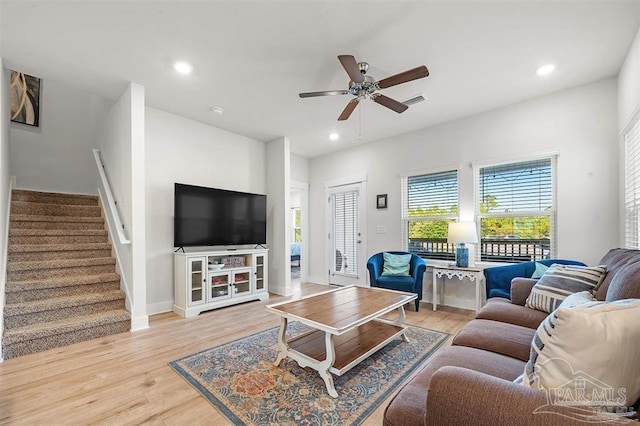 living area with light wood-style flooring, recessed lighting, visible vents, and stairway