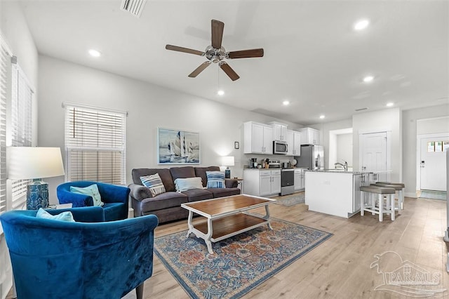 living area featuring a ceiling fan, light wood-type flooring, visible vents, and recessed lighting