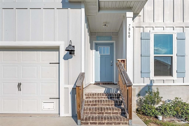 view of exterior entry featuring a garage and board and batten siding