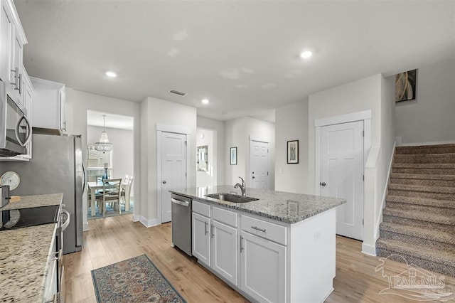 kitchen featuring appliances with stainless steel finishes, visible vents, a sink, and light wood-style flooring