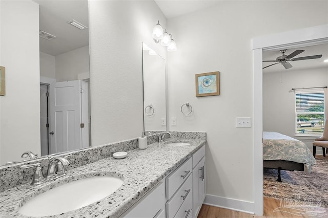 ensuite bathroom featuring a sink, visible vents, and baseboards