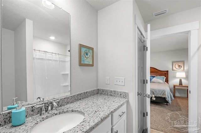 ensuite bathroom featuring a shower with shower curtain, visible vents, ensuite bathroom, and vanity