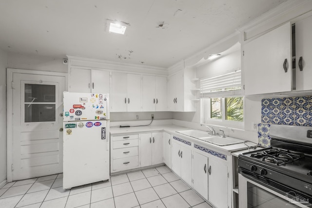 kitchen featuring light tile patterned floors, stainless steel gas range oven, a sink, freestanding refrigerator, and open shelves