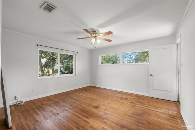 unfurnished room featuring hardwood / wood-style flooring, visible vents, and baseboards