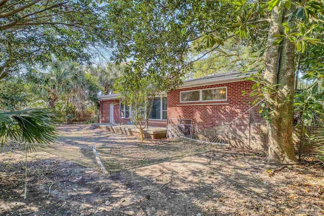 view of front of home with brick siding and a deck