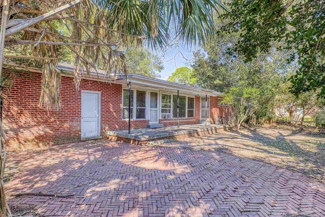 back of house featuring brick siding