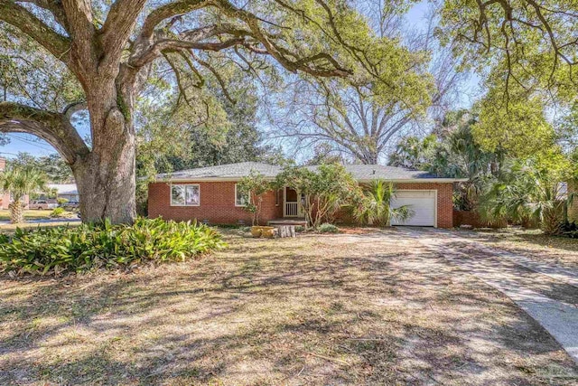 ranch-style home with concrete driveway, brick siding, and an attached garage