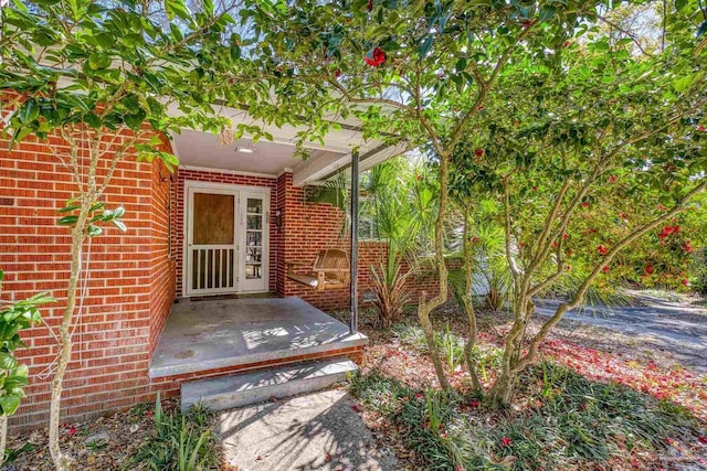 doorway to property featuring brick siding