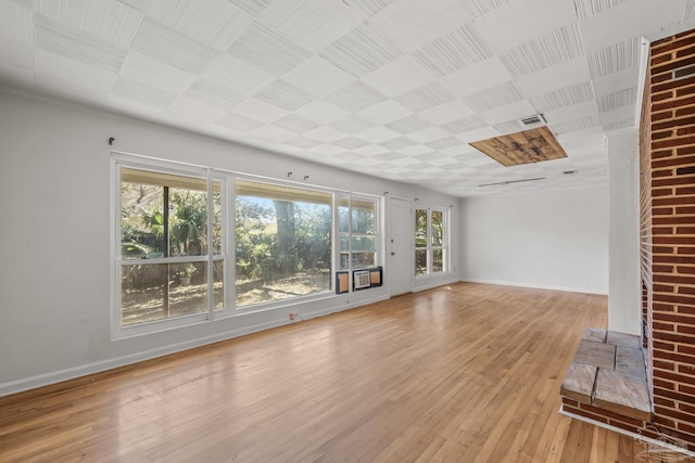 unfurnished living room featuring light wood-style floors, visible vents, and baseboards